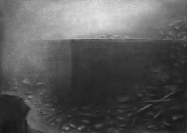 dark block on an abbys with stones around and little light from above